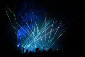 Vibrant laser show with green and blue lights captivating audience.